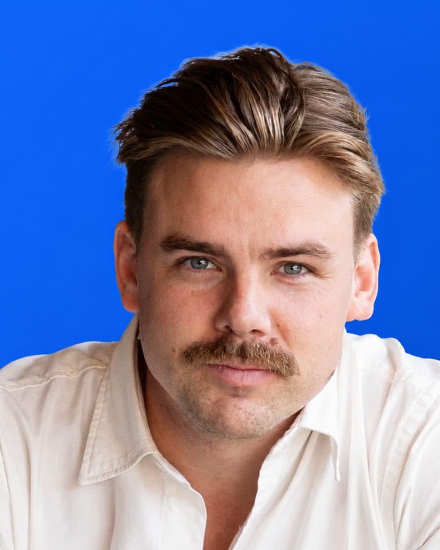 Portrait of Davis Hunt, product and editorial lead at Aculeus, in a white shirt against a signal-blue background