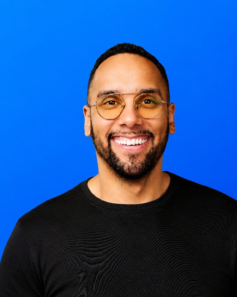 Portrait of Jeremy Jones, founder of Aculeus, in glasses against a signal-blue background